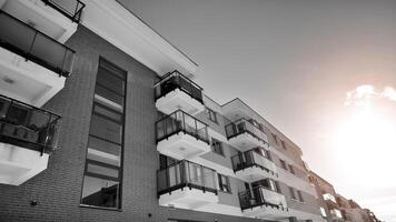 fragmento de el del edificio fachada con ventanas y balcones moderno Departamento edificios en un soleado día. fachada de un moderno residencial edificio. negro y blanco. foto