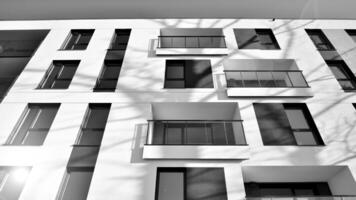 fragmento de un fachada de un edificio con ventanas y balcones moderno Departamento edificios en un soleado día. fachada de un moderno Departamento edificio. negro y blanco. foto