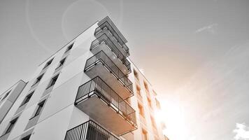 Fragment of the building's facade with windows and balconies. Modern apartment buildings on a sunny day. Facade of a modern residential building. Black and white. photo