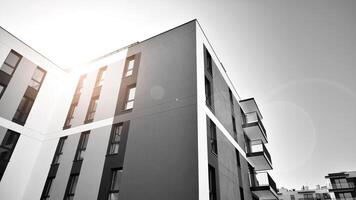 Fragment of the building's facade with windows and balconies. Modern apartment buildings on a sunny day. Facade of a modern residential building. Black and white. photo