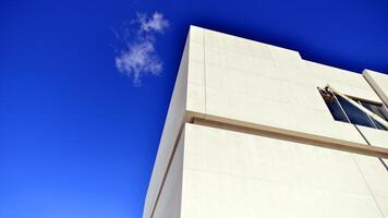 Sunlight and shadow on surface of white Concrete Building wall against blue sky background, Geometric Exterior Architecture in Minimal Street photography style photo