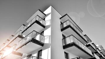 Fragment of a facade of a building with windows and balconies. Modern apartment buildings on a sunny day. Facade of a modern apartment building. Black and white. photo