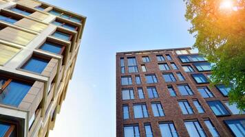 Eco architecture. Green tree and new residential building. Harmony of nature and modernity. Modern apartment building with new apartments in a green residential area. photo