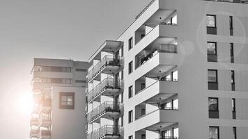Fragment of the building's facade with windows and balconies. Modern apartment buildings on a sunny day. Facade of a modern residential building. Black and white. photo