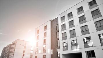Fragment of the building's facade with windows and balconies. Modern apartment buildings on a sunny day. Facade of a modern residential building. Black and white. photo