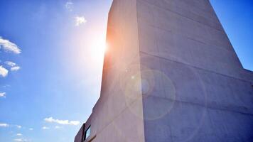 Sunlight and shadow on surface of white Concrete Building wall against blue sky background, Geometric Exterior Architecture in Minimal Street photography style photo