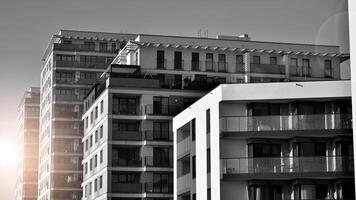 Fragment of the building's facade with windows and balconies. Modern apartment buildings on a sunny day. Facade of a modern residential building. Black and white. photo