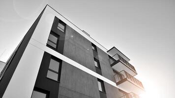 Fragment of the building's facade with windows and balconies. Modern apartment buildings on a sunny day. Facade of a modern residential building. Black and white. photo
