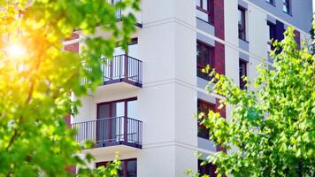 Modern residential building with new apartments in a green residential area. Eco architecture. Green tree and new apartment building. The harmony of nature and modernity. photo