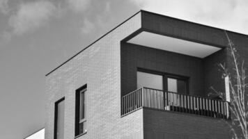 fragmento de el del edificio fachada con ventanas y balcones moderno Departamento edificios en un soleado día. fachada de un moderno residencial edificio. negro y blanco. foto