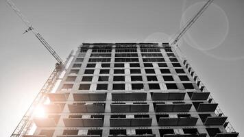 Fragment of the building's facade with windows and balconies. Modern apartment buildings on a sunny day. Facade of a modern residential building. Black and white. photo