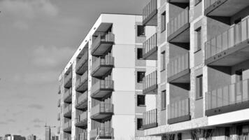 Fragment of the building's facade with windows and balconies. Modern apartment buildings on a sunny day. Facade of a modern residential building. Black and white. photo