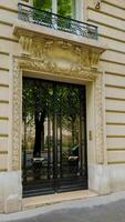 elegante parisino puerta con intrincado forjado hierro puertas y florido cantería, exhibiendo clásico francés arquitectura, ideal para viaje y real inmuebles temas foto