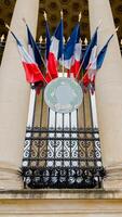 French tricolor flags adorn a Parisian buildings balcony, symbolizing Bastille Day pride in Paris photo