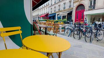 vistoso acera café ajuste con amarillo mesas y sillas en un europeo ciudad calle, sugerencia urbano estilo de vida y Alabama fresco comida conceptos foto