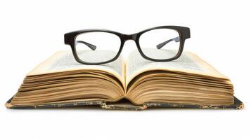 Open hardcover book with reading glasses on top, isolated on a white background photo