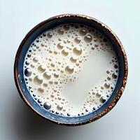 Milk in cup isolated on white background with shadow. Milk in blue cup full of calcium top view photo