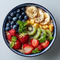 Oatmeal bowl isolated on white background with shadow. Oatmeal with variety of fruits top view. Oatmeal with strawberries, bananas, blueberries photo