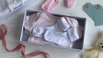 Baby and child clothes and knitted toys in carton box. video