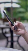 Side view close-up of young woman hands scrolling pictures in smartphone. Internet browsing. video