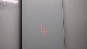 The interior of the elevator with a glass panel. The floor indicator lights up with a red number and movement down. Close-up video