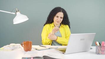 The wrist of the young woman using a laptop hurts. video