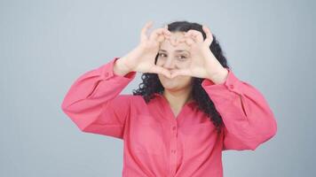 Young woman making heart sign at camera. video