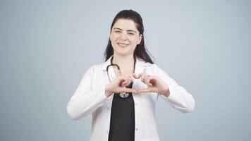 Doctor making heart looking at camera. video