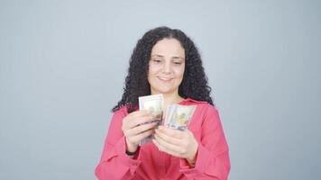 Young woman counting money looking at camera. video