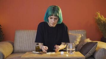 il giovane donna chi prende il pillole su il tavolo con tremito mani. suicidio. video