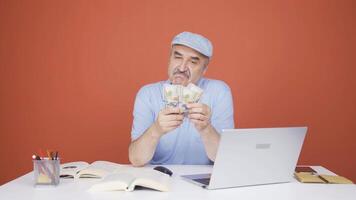 Man looking at laptop counting money. video