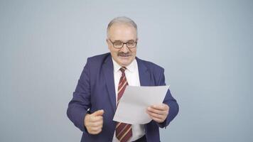 Businessman looks at the document in his hand and rejoices. video