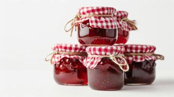 stack of homemade strawberry jam jars, gingham lids, isolated on a white background photo