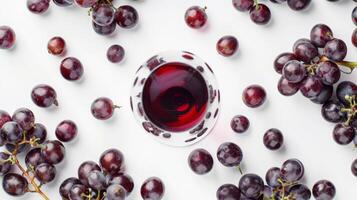 Aerial view of a wine glass surrounded by scattered grapes, isolated on white photo