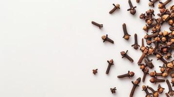 Scattered whole cloves on a white background with space for text photo