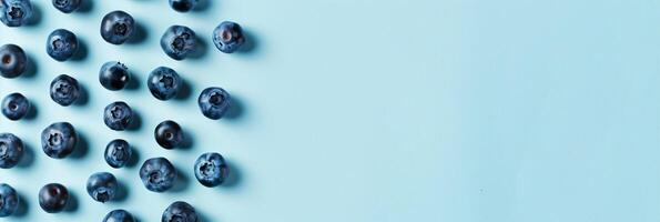 blueberries scattered across a pale blue surface, minimalist design with space for text photo