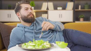 vegetariano uomo mangia insalata e è contento. video