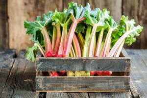 Fresh organic rhubarb stalks in a rustic wooden crate on a farmhouse table, perfect for culinary concepts and healthy eating themes photo