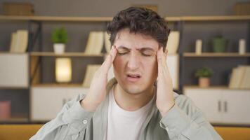 Young man with headache rubs his head. video