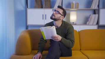 Young man reading a book at night. video