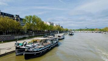 Scenic view of Seine River with moored boats and Parisian architecture, ideal for travel themes and Bastille Day celebrations photo