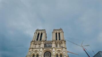 majestuoso notre dama catedral en París debajo restauracion con grúas en contra un nublado cielo, simbolizando cultural patrimonio y europeo arquitectura foto