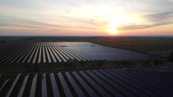 Aerial top view of a solar panels power plant. Photovoltaic solar panels at sunrise and sunset in countryside from above. Modern technology, climate care, earth saving, renewable energy concept. video