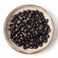 A dish of Black Ivory coffee beans, isolated on white background photo