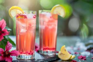 Two refreshing summer cocktails with lemon garnish and hibiscus flowers on a natural outdoor setting, perfect for summer parties and tropical themed events photo
