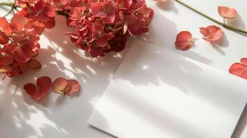 mockup of a white card beside red hydrangea bouquet, soft pastel tones photo