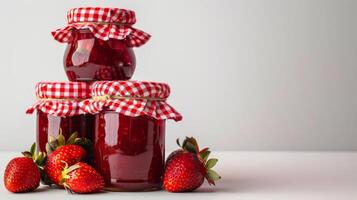 stack of homemade strawberry jam jars, gingham lids, isolated on a white background photo