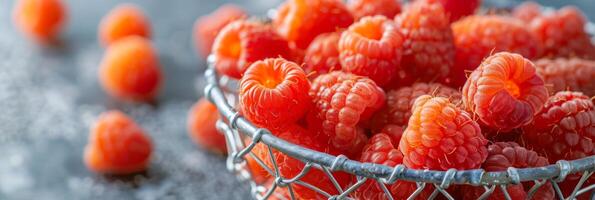 golden raspberries in a silver mesh basket, delicate and rare, soft focus background photo