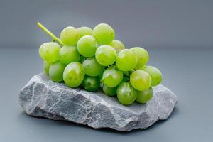 green grapes over stone isolated on a grey gradient background photo