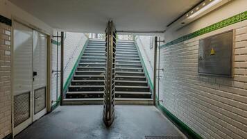 Empty subway station staircase with tiled walls and art nouveau details, suitable for concepts of urban transportation, commuting, and metropolitan infrastructure photo